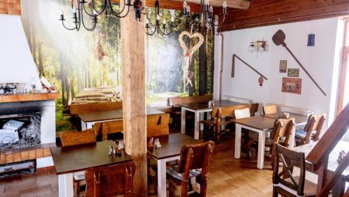 un restaurant avec des tables, des chaises et une cheminée dans l'établissement Penzion Pod Houskou, à Blatce