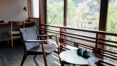 a room with a table and a chair and a window at Kobayashiya -Kinosaki Onsen- in Toyooka