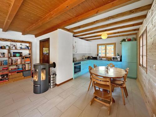 eine Küche mit einem Tisch und eine Küche mit blauen Schränken in der Unterkunft Chalet Albarose - Vercorin in Vercorin