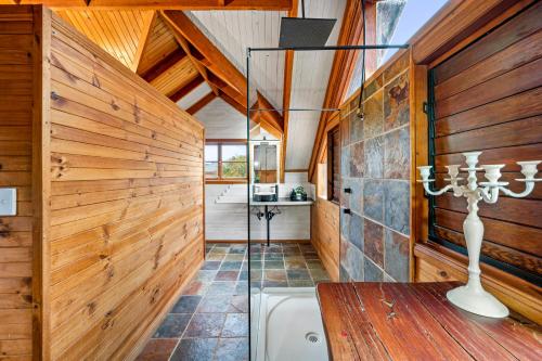 a bathroom with wooden walls and a bath tub at Acreage Home in The Heart of Hunter Valley in Ellalong