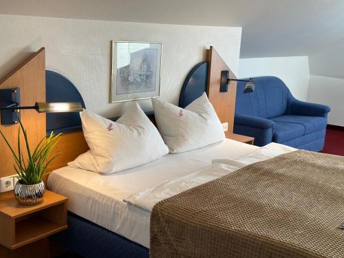 ein Hotelzimmer mit einem Bett und einem blauen Stuhl in der Unterkunft Fährhaus Farge Bremen in Bremen