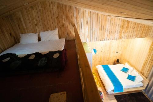 a small room with a bed in a wooden cabin at THE HIMALAYAN WOODS, CHAUKORI in Chaukori
