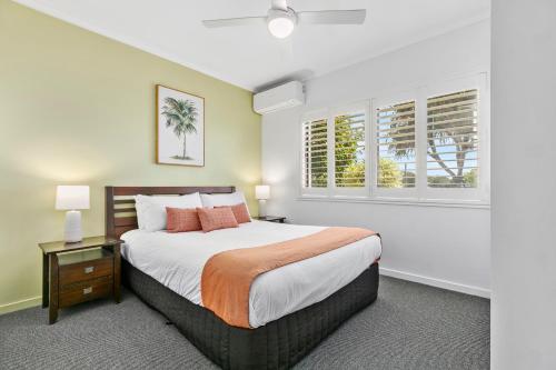 a bedroom with a large bed and two windows at Culgoa Point Beach Resort in Noosa Heads