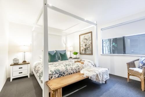 a white bedroom with a bed and a window at Peppi Lane Stay in Margaret River Town