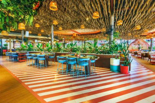 a restaurant with tables and chairs and plants at The Cruise Hotel in Pattaya