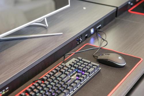 a computer keyboard and a mouse on a desk at Rose Bay Hotel in Busan