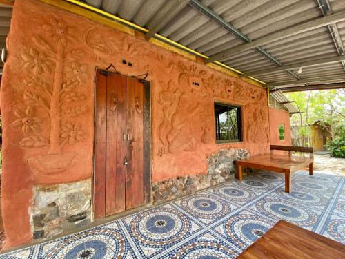 a room with a wooden door and a table at Numpu Baandin in Sam Roi Yot