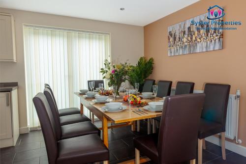 uma sala de jantar com mesa e cadeiras em Syster Properties Serviced Accommodation Leicester 5 Bedroom House Glen View em Leicester