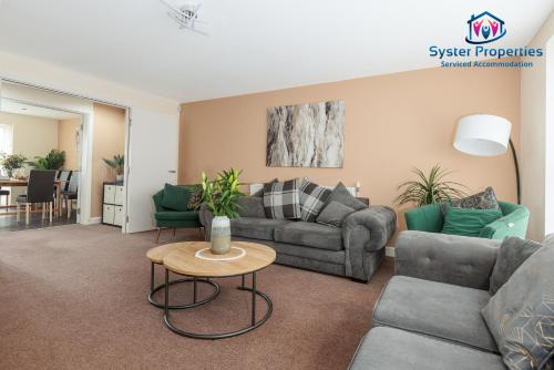 ein Wohnzimmer mit einem Sofa und einem Tisch in der Unterkunft Syster Properties Serviced Accommodation Leicester 5 Bedroom House Glen View in Leicester