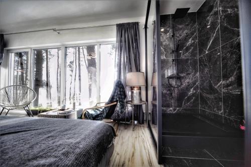 a bedroom with a bed and a large window at GaujaClub - our BOSE and Bang&Olufsen lofts on a lake in Gauja