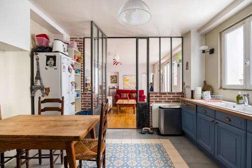une cuisine avec une table en bois et une salle à manger dans l'établissement Country home in Paris, à Paris