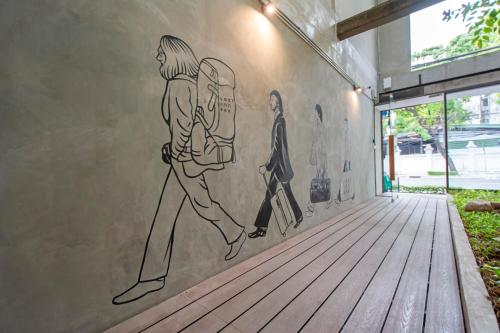a mural of a man walking down a hallway at Lost Inn BKK in Bangkok