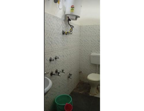 a bathroom with a toilet and a sink at Hotel Krish Motel and Restaurant, Uttarkashi in Uttarkāshi