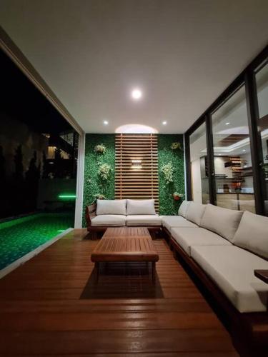 a living room with a white couch and a table at Villa Daun at Dago Village in Bandung