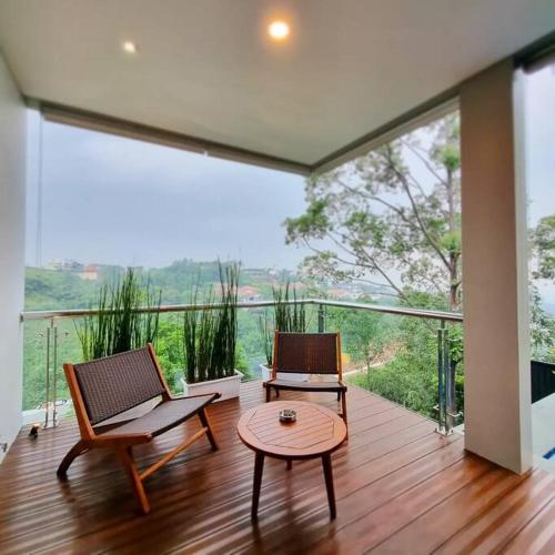 a room with two chairs and a table on a balcony at Villa Daun at Dago Village in Bandung