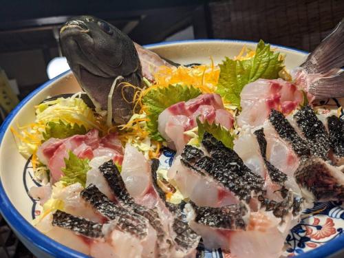a plate of food with a salad and a bird on it at private accommodation隠岐貸切古民家宿くすぶるハウス in Okinoshima