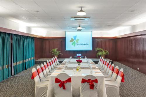 a conference room with a long table with red bows at Club Mahindra Puducherry in Pūrnānkuppam