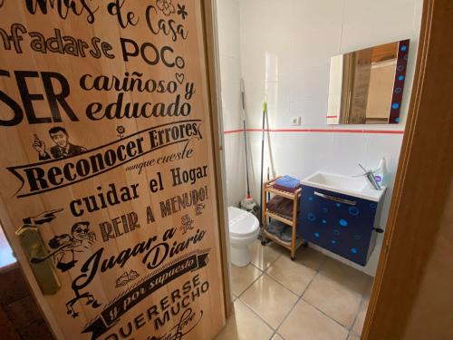 a bathroom with a toilet and a sign on the door at Casa Duna in San Martín de la Vega