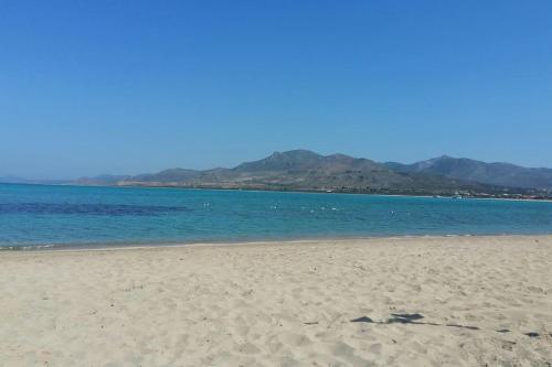 una playa con el océano y las montañas en el fondo en Almiriki, en Elafonisos