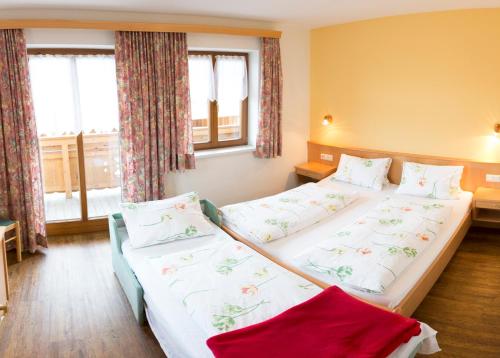 two beds in a room with two windows at Ausserraingut in Flachau