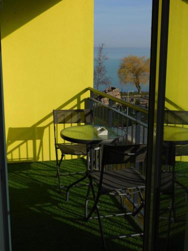 a patio with a table and chairs on a balcony at Chill & Relax Apartment in Siófok