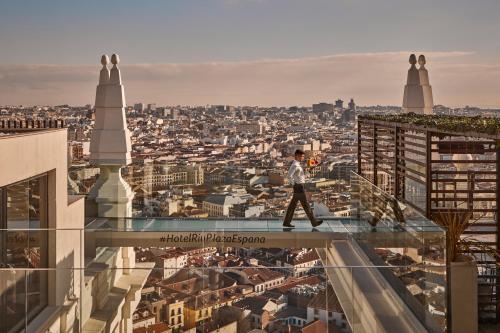 a man walking on the glass floor of a building at Riu Plaza España in Madrid