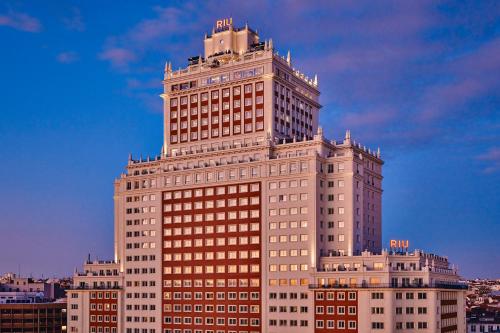 a tall white building with a lot of windows at Riu Plaza España in Madrid