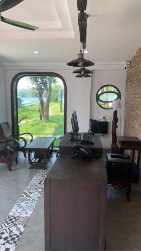 a room with a kitchen with a table and a room with a window at La Y Riverview in Hue