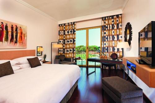 um quarto de hotel com uma cama e uma televisão em Mövenpick Ambassador Hotel Accra em Accra