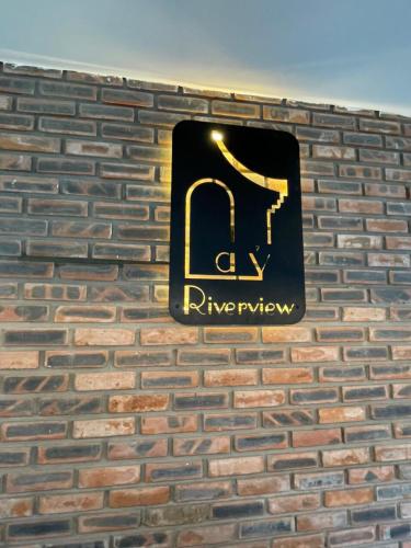 a sign on the side of a brick wall at La Y Riverview in Hue