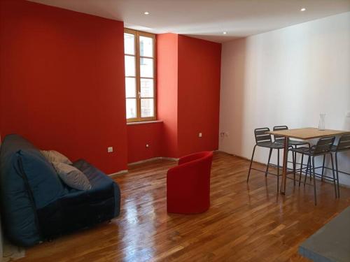 ein Wohnzimmer mit einem Sofa und einem Tisch in der Unterkunft Appartement 1er étage in Largentière