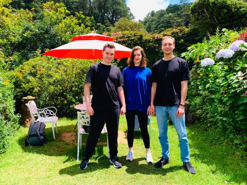 a group of three people standing under an umbrella at Miliya Guest House in Nuwara Eliya