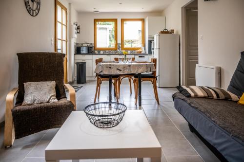 een woonkamer met een tafel en een keuken bij Gite Pak'Home maison à la campagne 3 étoiles avec wifi in Lombray