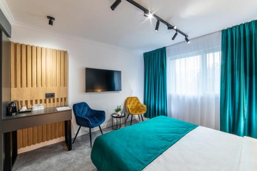 a hotel room with a bed and a desk and chairs at Campeador Inn in Cluj-Napoca