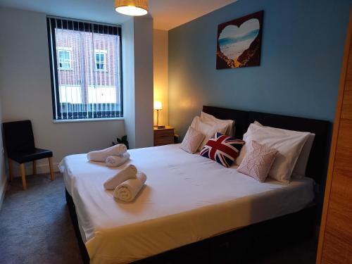 a bedroom with a bed with towels on it at Spacious 2 Bed Apartment Norwich, Close To Station and City centre in Norwich