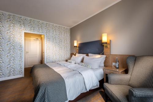 a hotel room with a bed and two chairs at Hotel Wassersleben in Flensburg