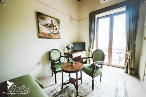 a living room with a couch and a table and chairs at SOFIA BOUTIQUE HOTEL in Kérynia