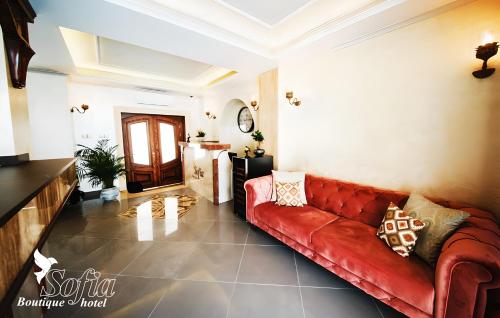 a living room with a red leather couch at SOFIA BOUTIQUE HOTEL in Kérynia