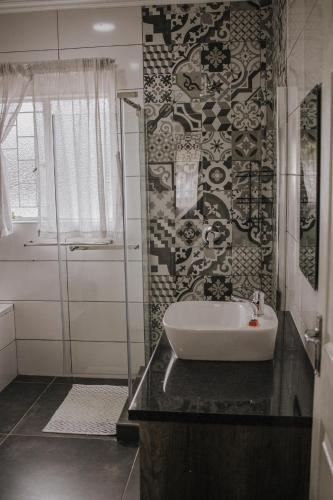 a bathroom with a sink and a glass shower at Casa Leitao Lodge in Phalaborwa