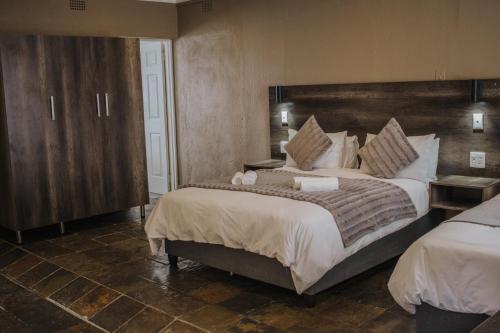 a bedroom with a large bed with a large headboard at Casa Leitao Lodge in Phalaborwa