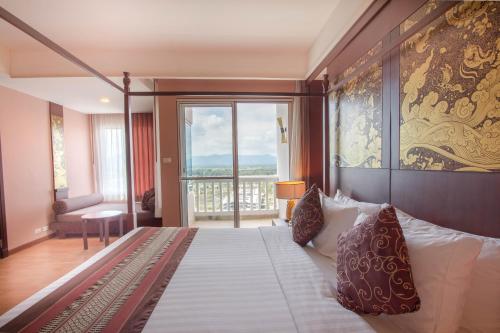 a bedroom with a large bed and a large window at Grand Pacific Sovereign Resort & Spa in Cha Am
