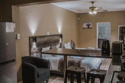 a dining room with a table and chairs and a bed at Casa Leitao Lodge in Phalaborwa