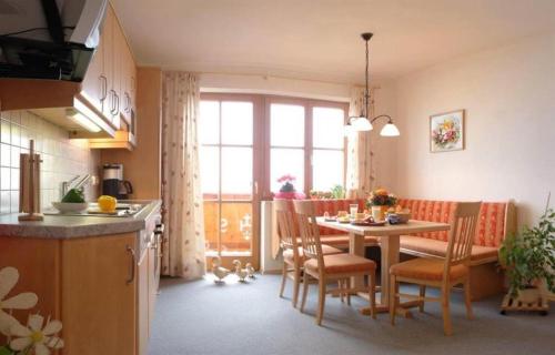 Präau-Gut في دورفغاشتاين: مطبخ وغرفة طعام مع طاولة وكراسي