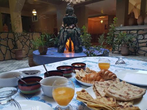 einen Tisch mit einem Teller Essen und einer Statue in der Unterkunft Riad Lalla in Tinghir
