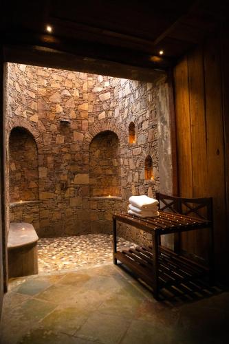 a room with a stone wall and a table with towels at The Baagh Ananta Elite Ranthambore in Sawāi Mādhopur