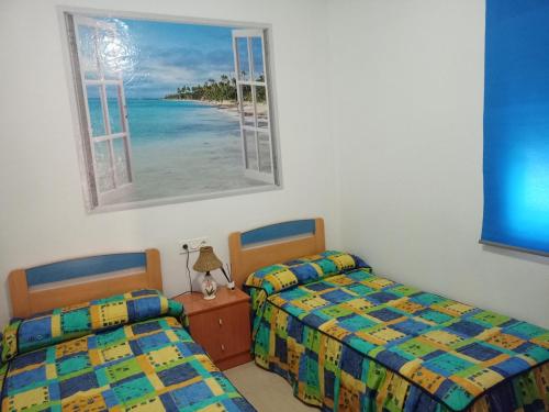 - 2 lits dans une chambre avec fenêtre dans l'établissement Alojamiento roquetas de mar, à Roquetas de Mar