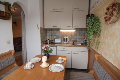 a kitchen with a wooden table with plates on it at Ferienwohnung Am Forstamt in Ramsau