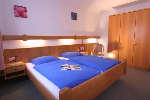 a bedroom with a bed with blue sheets and blue pillows at Ferienwohnung Am Forstamt in Ramsau