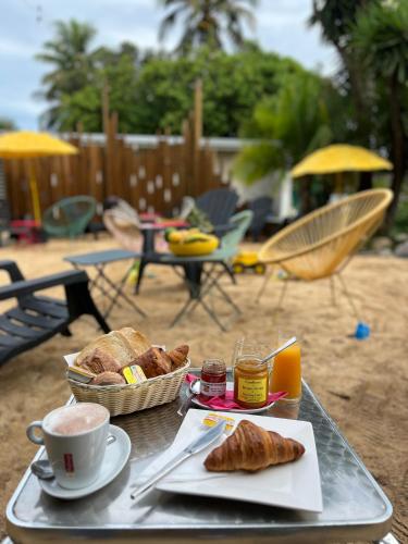 a table with a tray of bread and a cup of coffee at Le Passiflore in Kumak