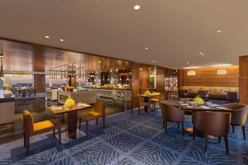 a restaurant with tables and chairs and a bar at Sheraton Grand Bengaluru Whitefield Hotel & Convention Center in Bangalore